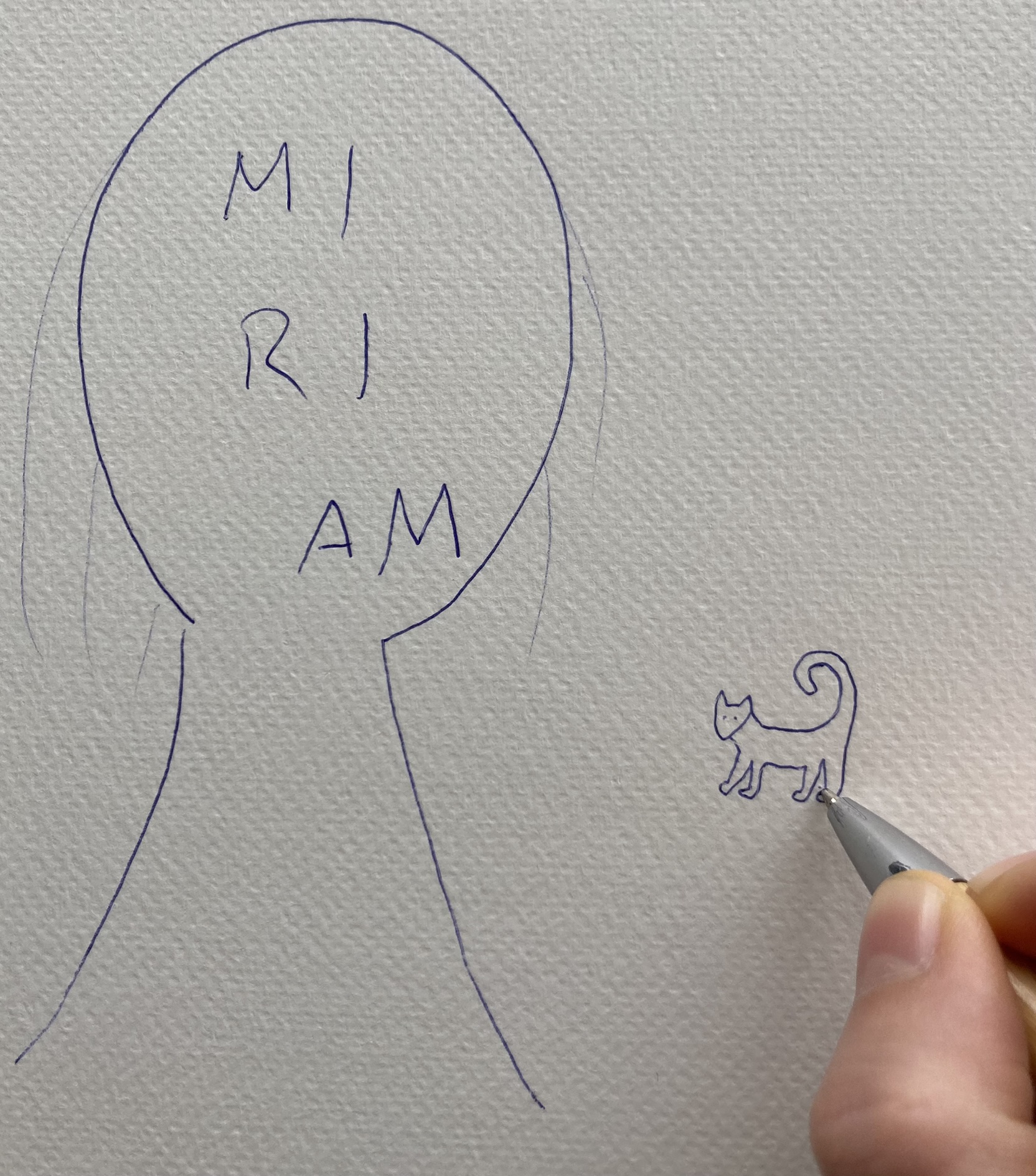 Neben einem mit Kugelschreiber gezeichneten Kopfumriss, in dem Miriam steht, zeichnet eine Hand eine Katze.
